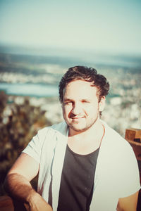 Portrait of young man wearing sunglasses at beach against sky