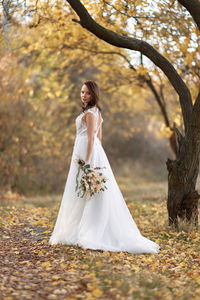Side view of bride standing in forest