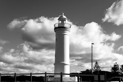 Low angle view of lighthouse by building against sky