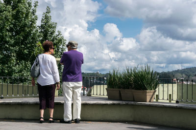 Rear view of couple standing against sky