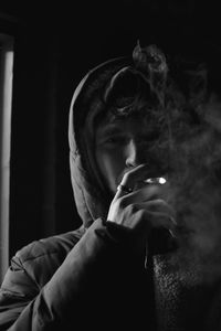 Close-up of young man smoking at night