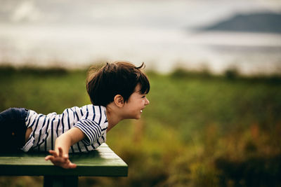 Side view of smiling girl lying on land