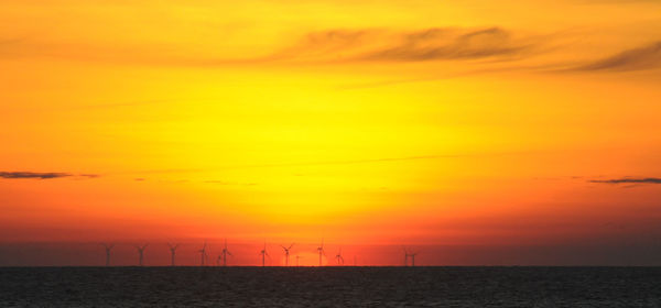 Scenic view of sea against orange sky