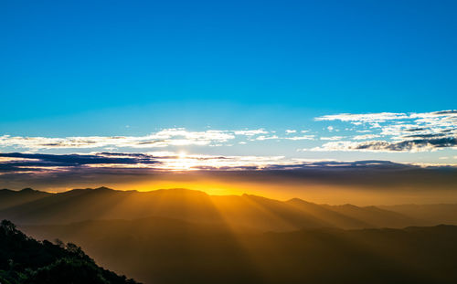 Scenic view of silhouette mountains against sky during sunset