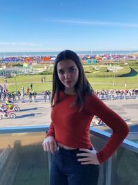 Portrait of smiling woman standing against sky