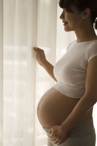 Side view of woman touching window