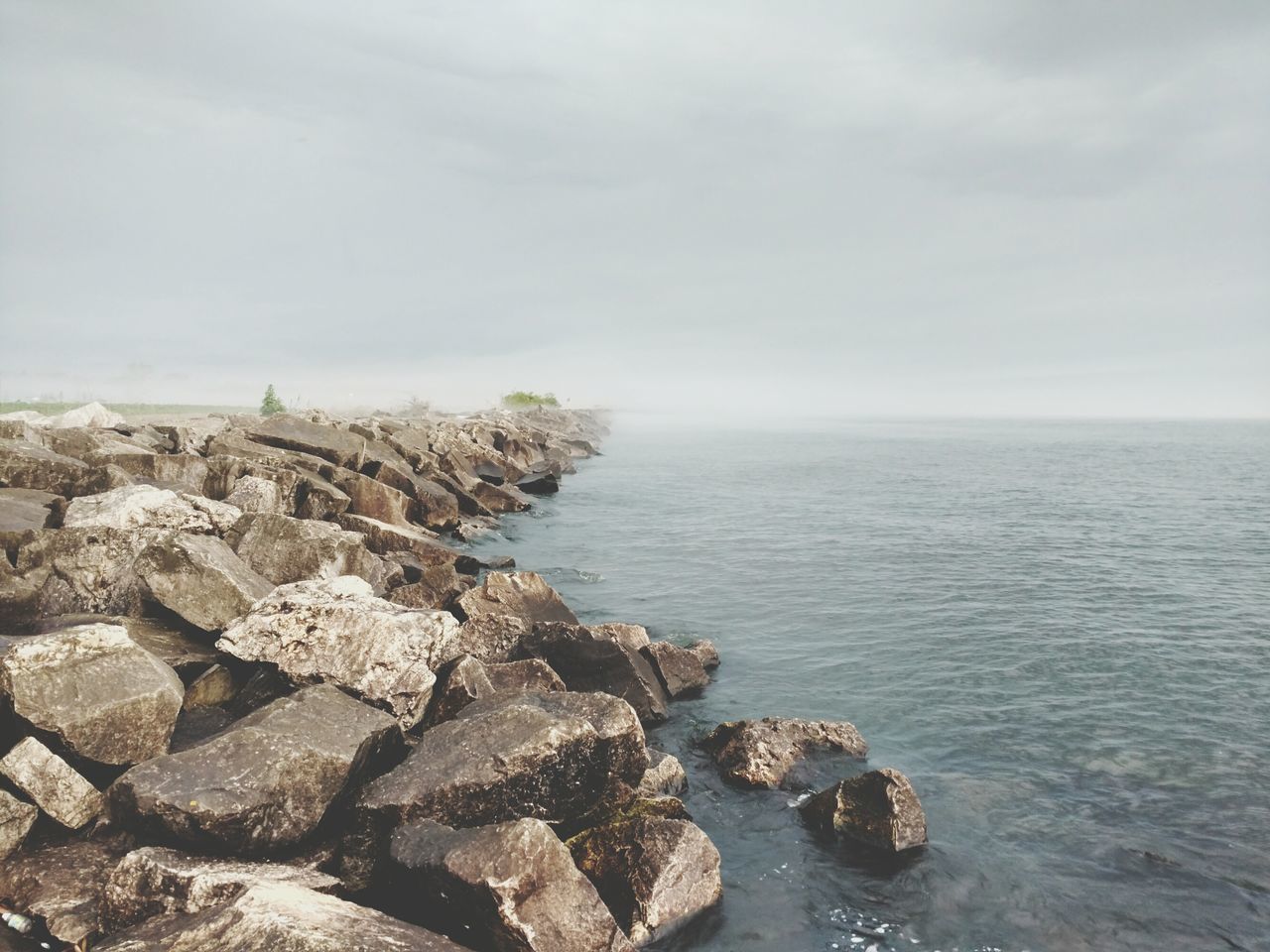 ROCKS IN SEA AGAINST SKY