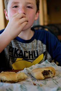 Portrait of boy eating food at home