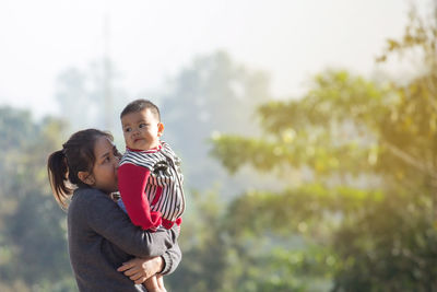 Rear view of mother and daughter against blurred background