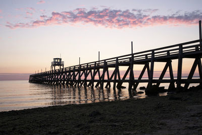 Pier over sea against sky during sunset