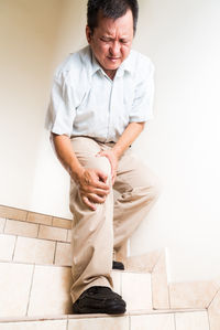 Man with knee pain standing on steps