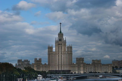 Buildings in city against cloudy sky