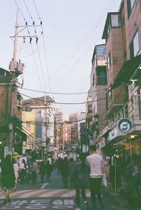 People walking on road along buildings