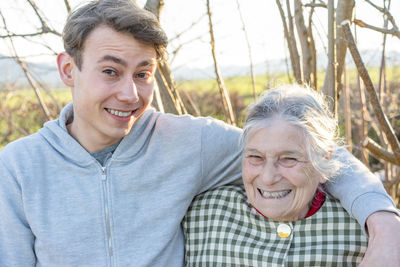 Portrait of happy grandmother with grandson against trees