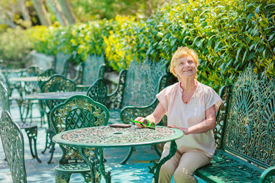 Mature attractive woman traveler sitting alone on the terrace of coffee shop