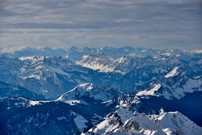 Aerial view of snowcapped mountains against sky