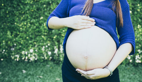 Midsection of woman with hand on field