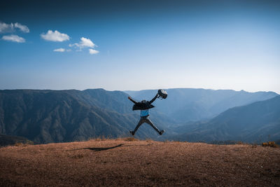 Low angle view of person paragliding on land against sky