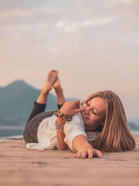 Portrait of woman lying down against sky