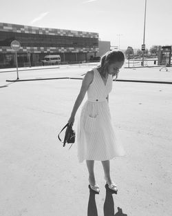 Full length of woman with umbrella standing on land