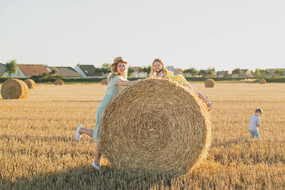 Rear view of woman standing on hay