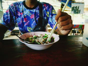 Close-up of person eating food on table