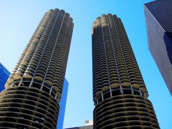 Low angle view of skyscrapers against blue sky