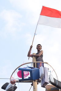 Woman sitting on boat against sky