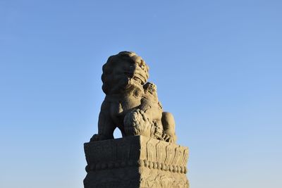 Low angle view of statue against blue sky