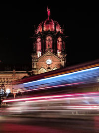 Light trails on street against buildings at night