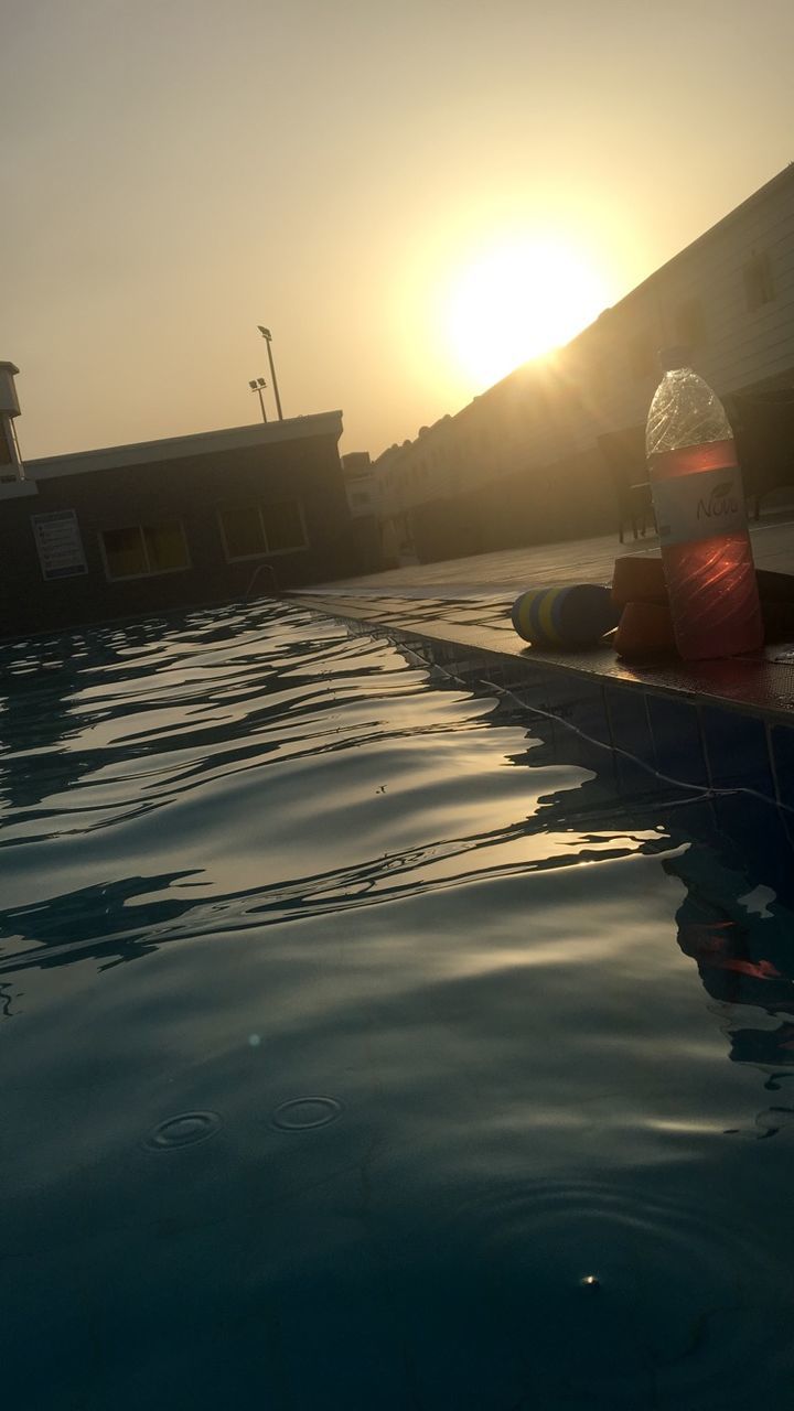 REFLECTION OF MAN IN SWIMMING POOL AT SUNSET