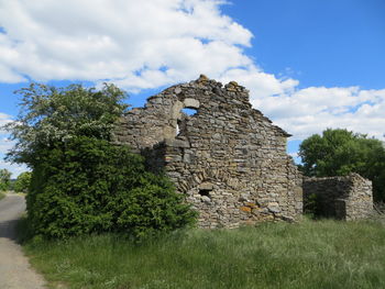 Old ruin building on field against sky