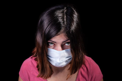 Portrait of a beautiful young woman over black background