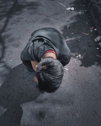 High angle view of boy kneeling on road