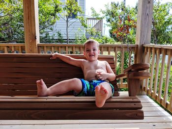 Portrait of happy boy sitting on wood