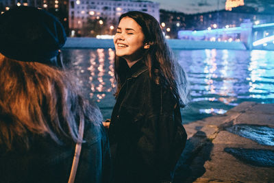 Beautiful woman smiling while standing in water at night