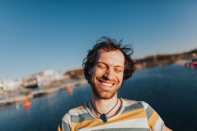 Portrait of smiling young man against sky