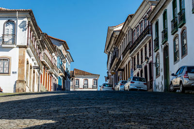 Street amidst buildings against blue sky