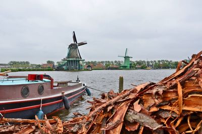 Traditional windmill in water against sky