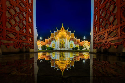 Illuminated building against sky at night