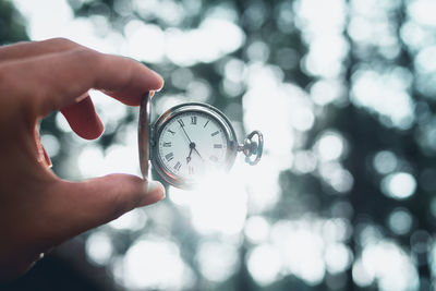 Cropped hand holding pocket watch