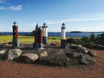 Lighthouse by sea against sky