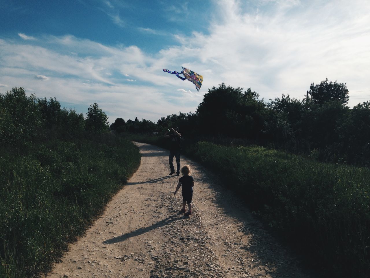 tree, lifestyles, leisure activity, full length, transportation, sky, men, bicycle, road, walking, shadow, grass, street, sunlight, cloud - sky, riding, on the move, sport