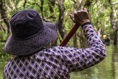 Rear view of man holding umbrella