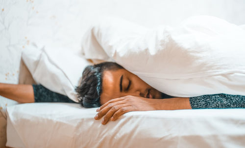 Portrait of woman sleeping on bed