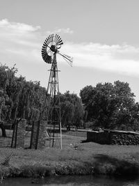 Traditional windmill on field against sky