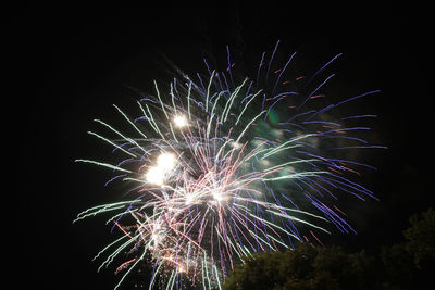 Low angle view of firework display at night