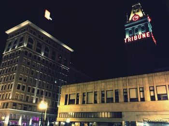 Low angle view of illuminated clock tower at night