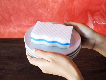 Midsection of person holding ice cream on table