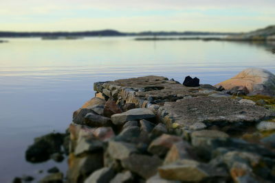 Rocks in lake against sky